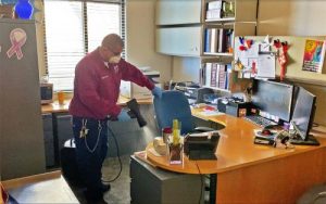 worker disinfecting office