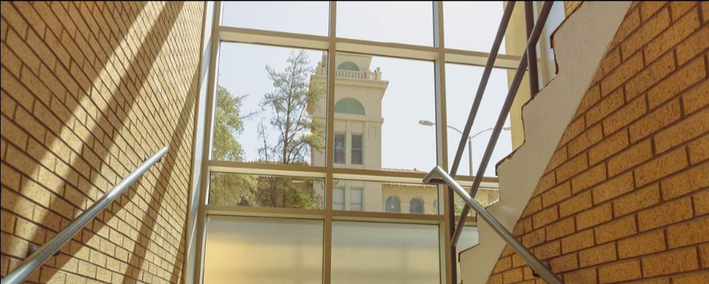Building with a large window, in the window you can view the tip of another building. 