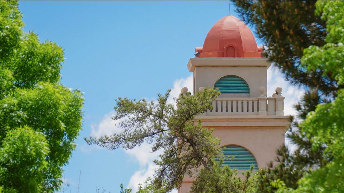 Tip of a building that had beige and slight orange at the tip, with turquoise where windows should be.  